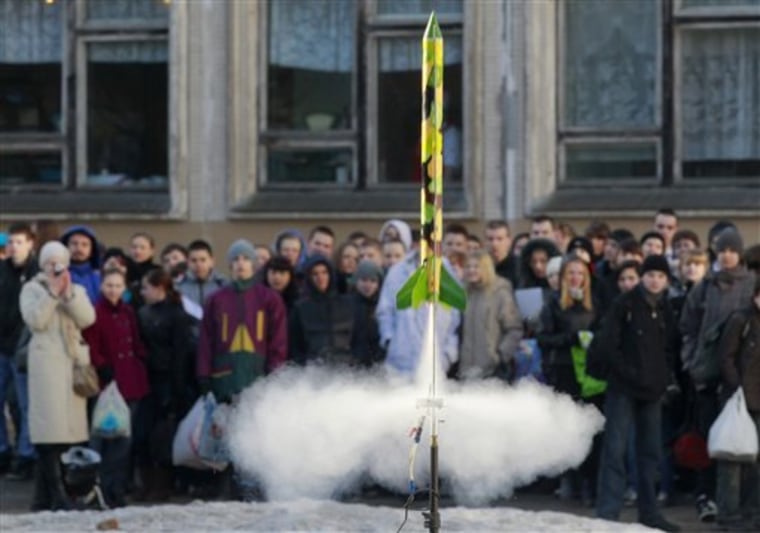 Children watch a model rocket blasting off during a celebration of the 50th anniversary of the Yuri Gagarin's first manned flight into space at a school in St. Petersburg, Russia, Tuesday, April 12, 2011. (AP Photo/Dmitry Lovetsky)